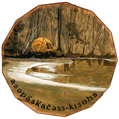 An octagonal artwork featuring a cabin by a river, surrounded by trees, with the text "asepáskáčėss-kisohs" at the bottom.