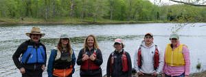 People standing in front of a river.