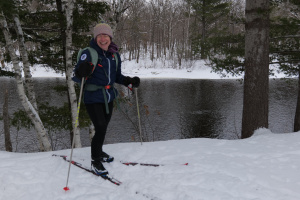 A woman on skis in front of a river