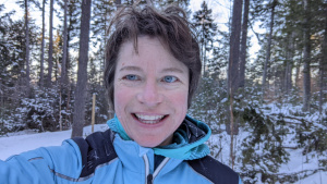 A close up woman's face in a snowy landscape.