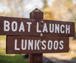 A brown wooden sign that says "Lunksoos Boat Launch."