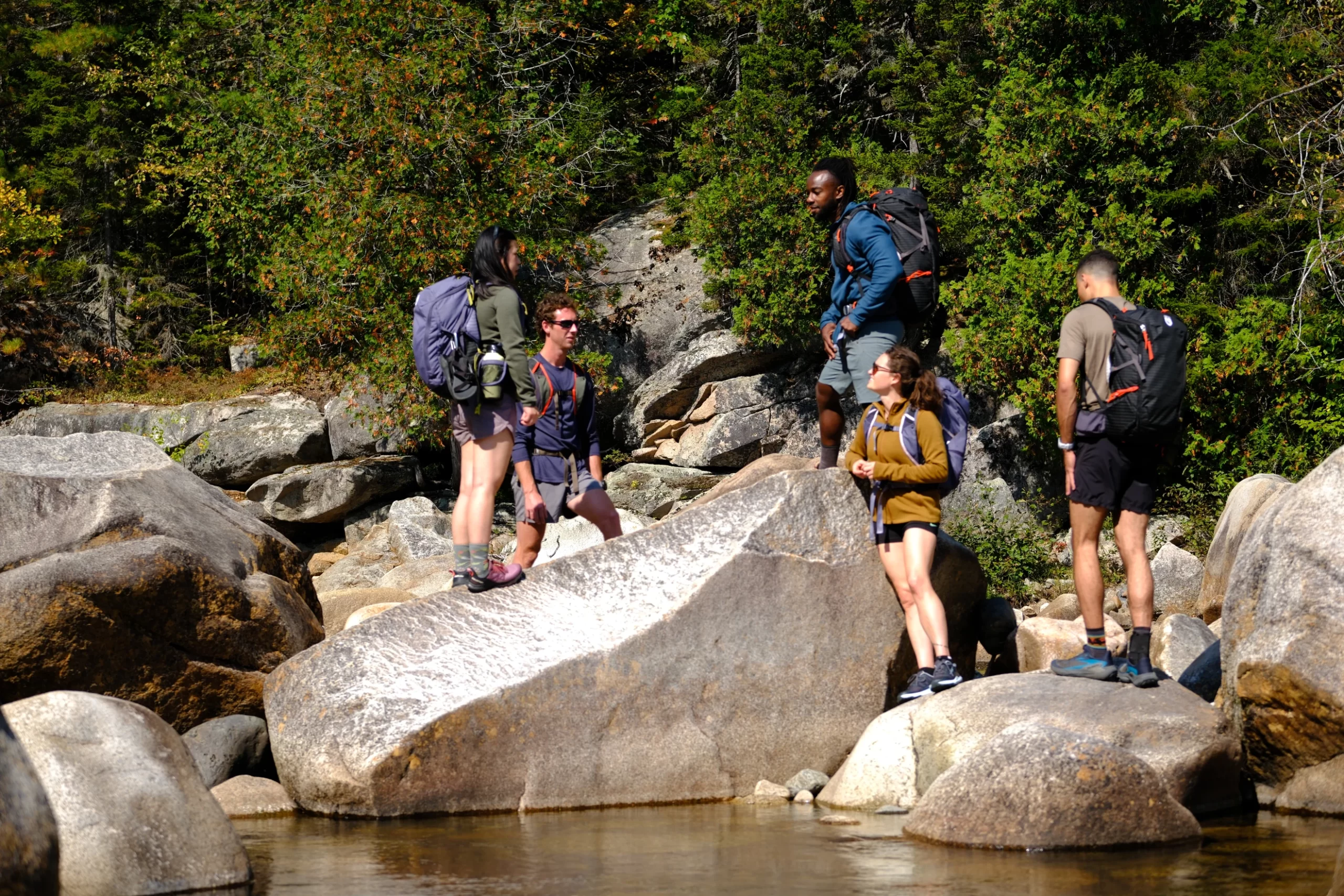 A group of hikers standing on boulders at Orin Falls