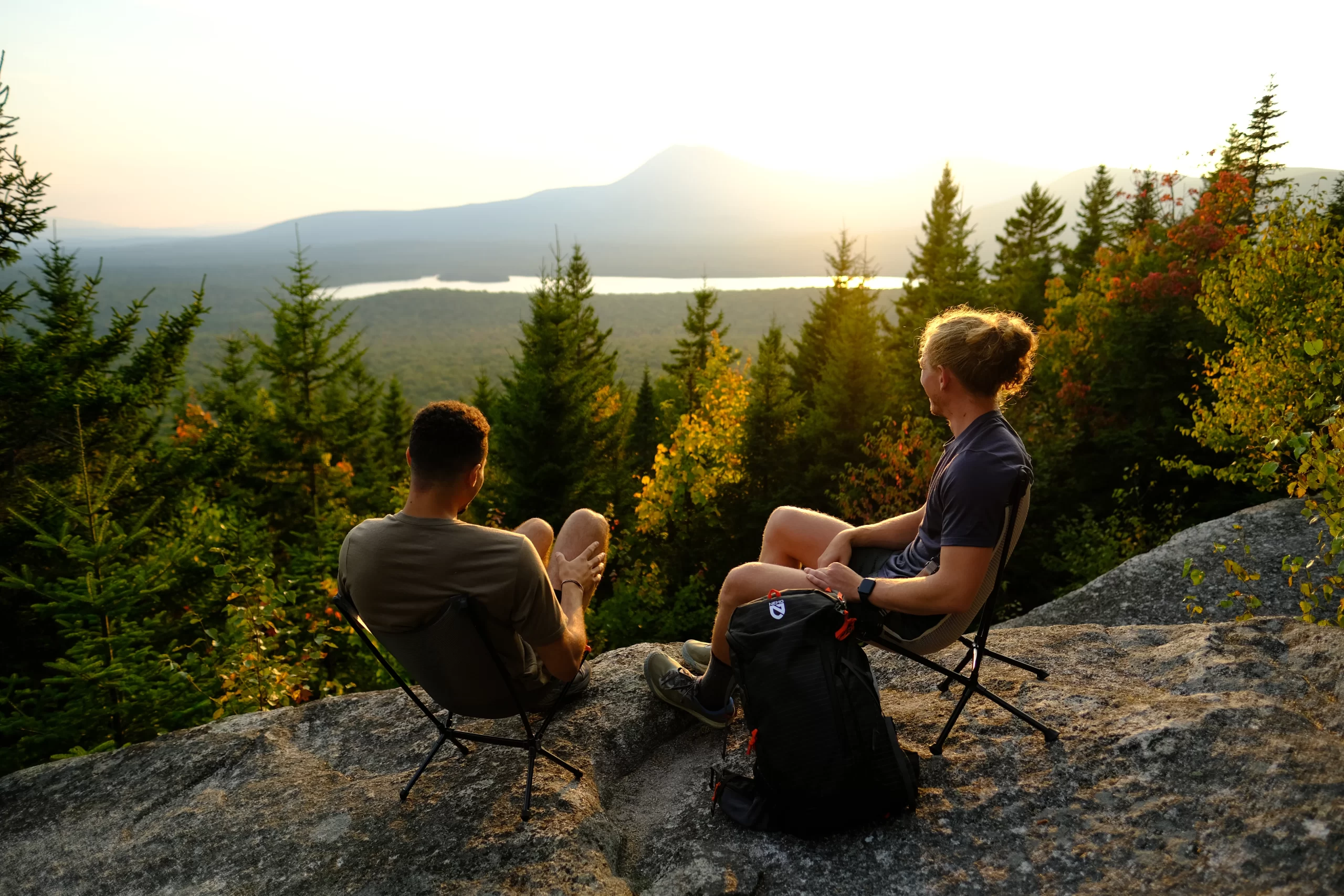 Two campers sitting atop Barnard Mountain viewing the sunset
