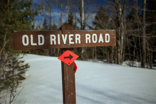 A brown wooden sign "Old River Road."