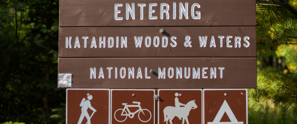 A wooden sign reads: Entering Katahdin Woods & Waters National Monument.