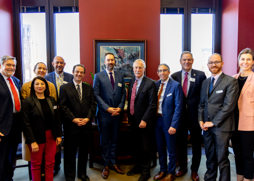 A group of men and women gathered in a formal photograph with Senator Angus King of Maine.