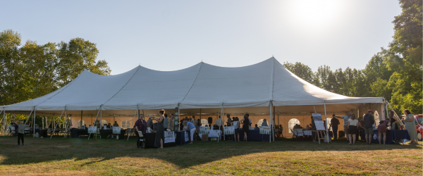 A large event tent in a sunny field.